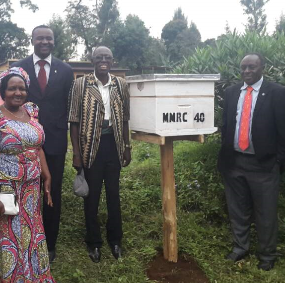 President Dr. Z.Mmbando in a black suit and behind Rotarian Mrs. Vicky Sariko & past Presidents G.Kawiche and Fred Temu on the day the hives were being distributed. Six hives already have new bee colonies.